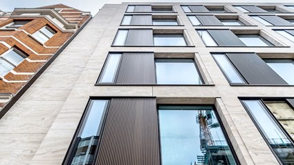 The cladding on Berners Mews used Travertine Stone and bronze profiled panels, as well as bronze punch hole windows.